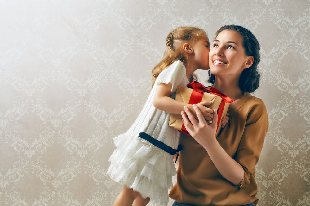 Jolie Jeune Femme Avec Un Cadeau De Fête Des Mères Et Un Bouquet