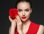 femme tenant une rose éternelle rouge près de son visage