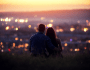 Couple qui admire enlacés une ville sous un coucher de soleil