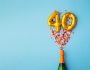 Bouteille de champagne qui explose avec des confettis et des ballons qui forment le nombre 40