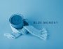 Un mug entouré d'une écharpe bleue avec écrit à côté : le Blue Monday, le jour le plus triste de l'année