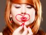 Femme rousse qui fait semblant d'embrasser au travers d'un coeur
