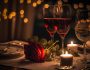 Deux verres d'alcool et une rose rouge posés sur une table de restaurant