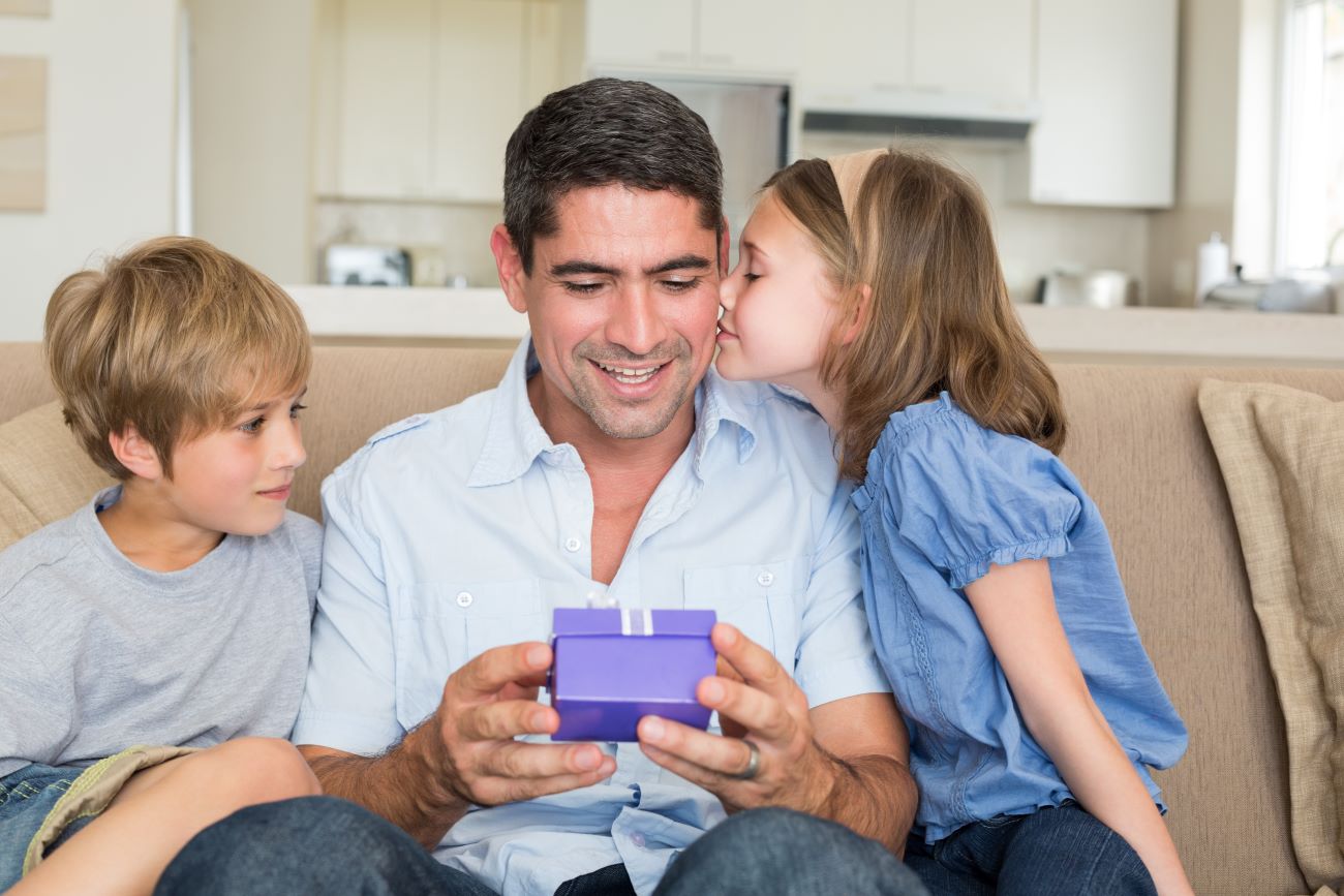 Un papa recevant un cadeau de ses enfants