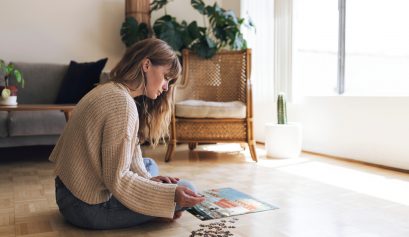 Femme assise dans son salon qui réfléchit devant un puzzle photo personnalisé