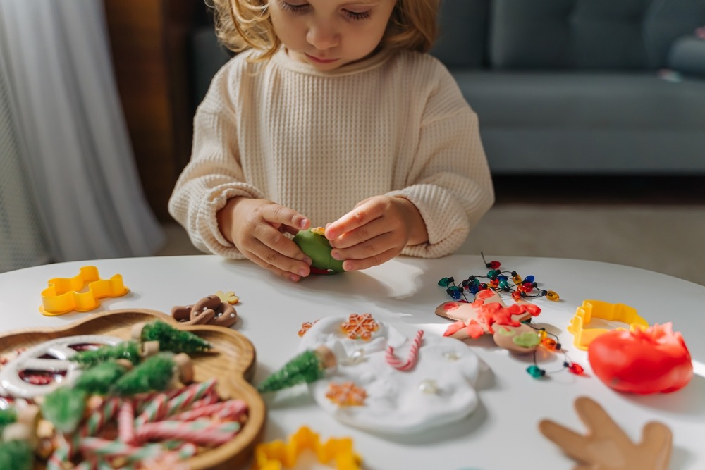 Une petite fille faisant une décoration en pâte à modeler