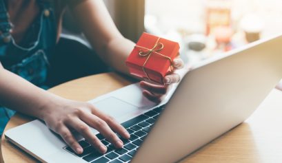 Femme qui utilise une carte cadeau multi-enseignes en ligne sur son ordinateur portable