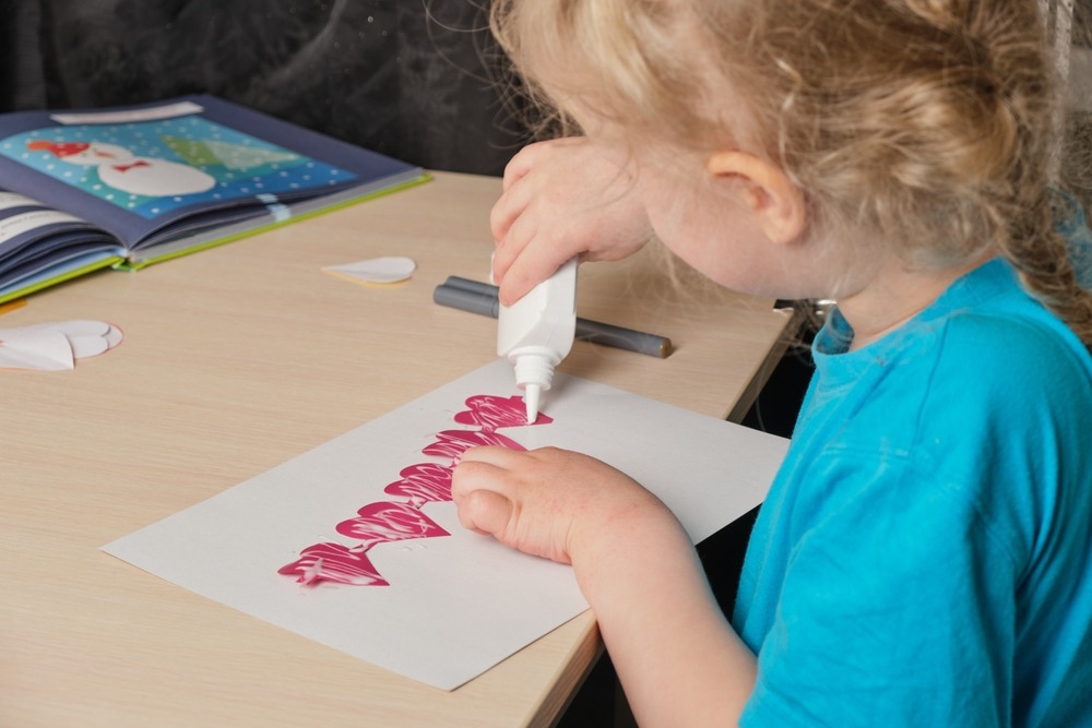 Un enfant en train de fabriquer une carte