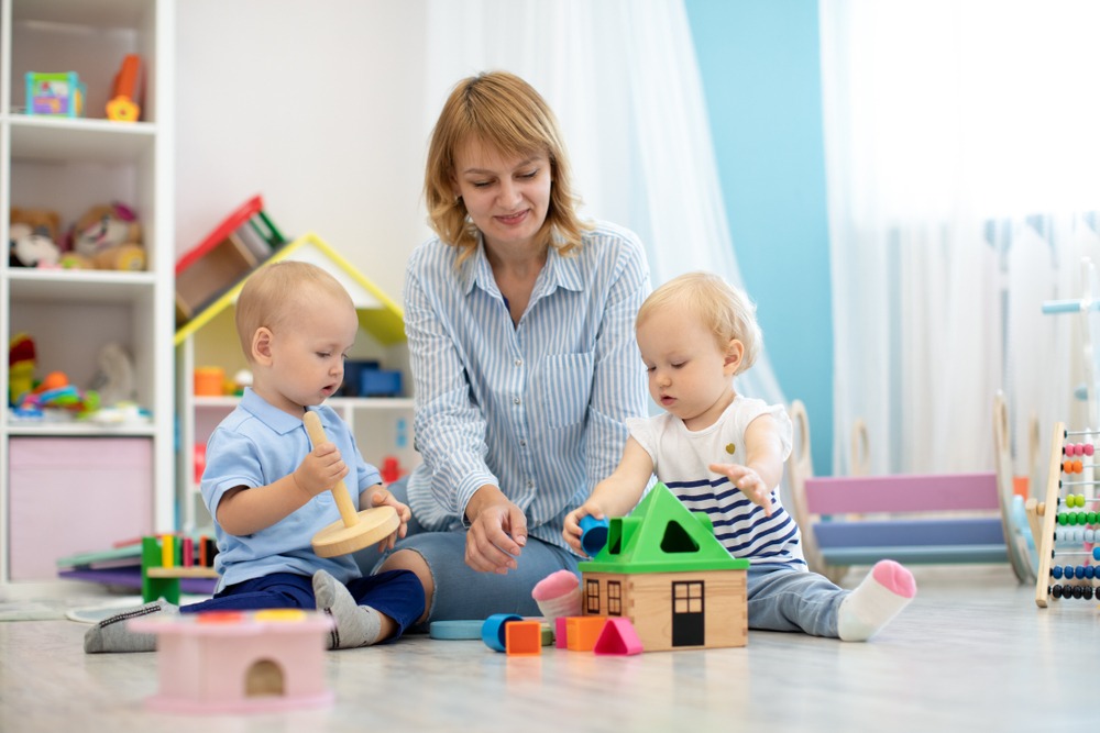 Une nounou s'occupe de 2 enfants à la crèche