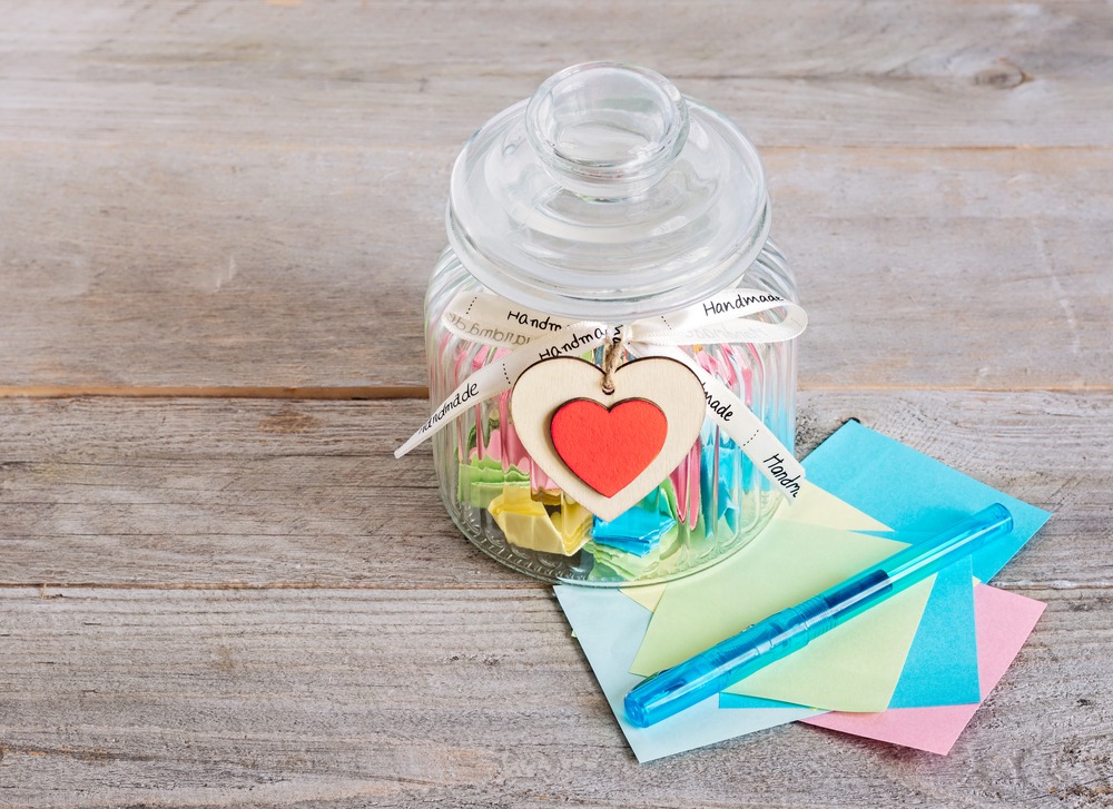 Un pot en verre rempli de petits papiers