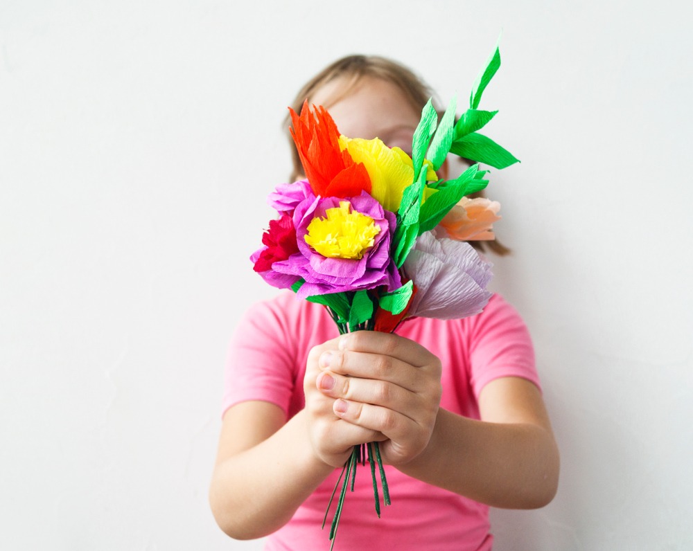 Petite fille avec bouquet de fleurs en papier