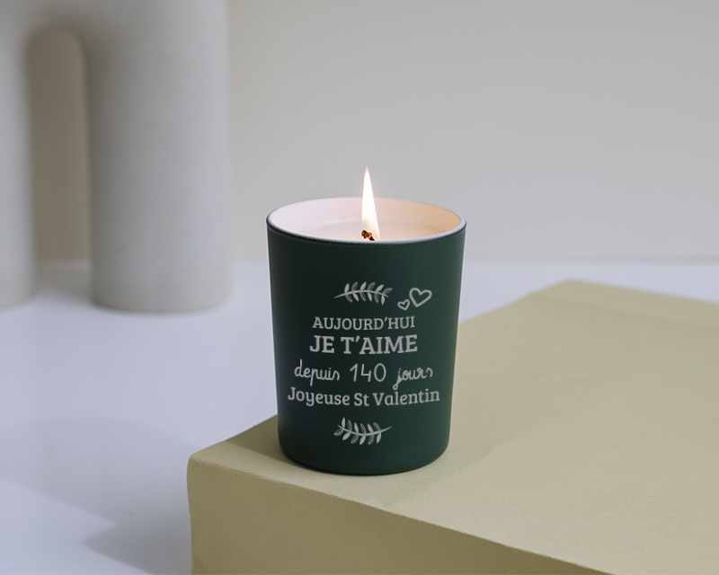 Bougie Saint-Valentin disposée sur une couverture douce et entourée de roses éternelles