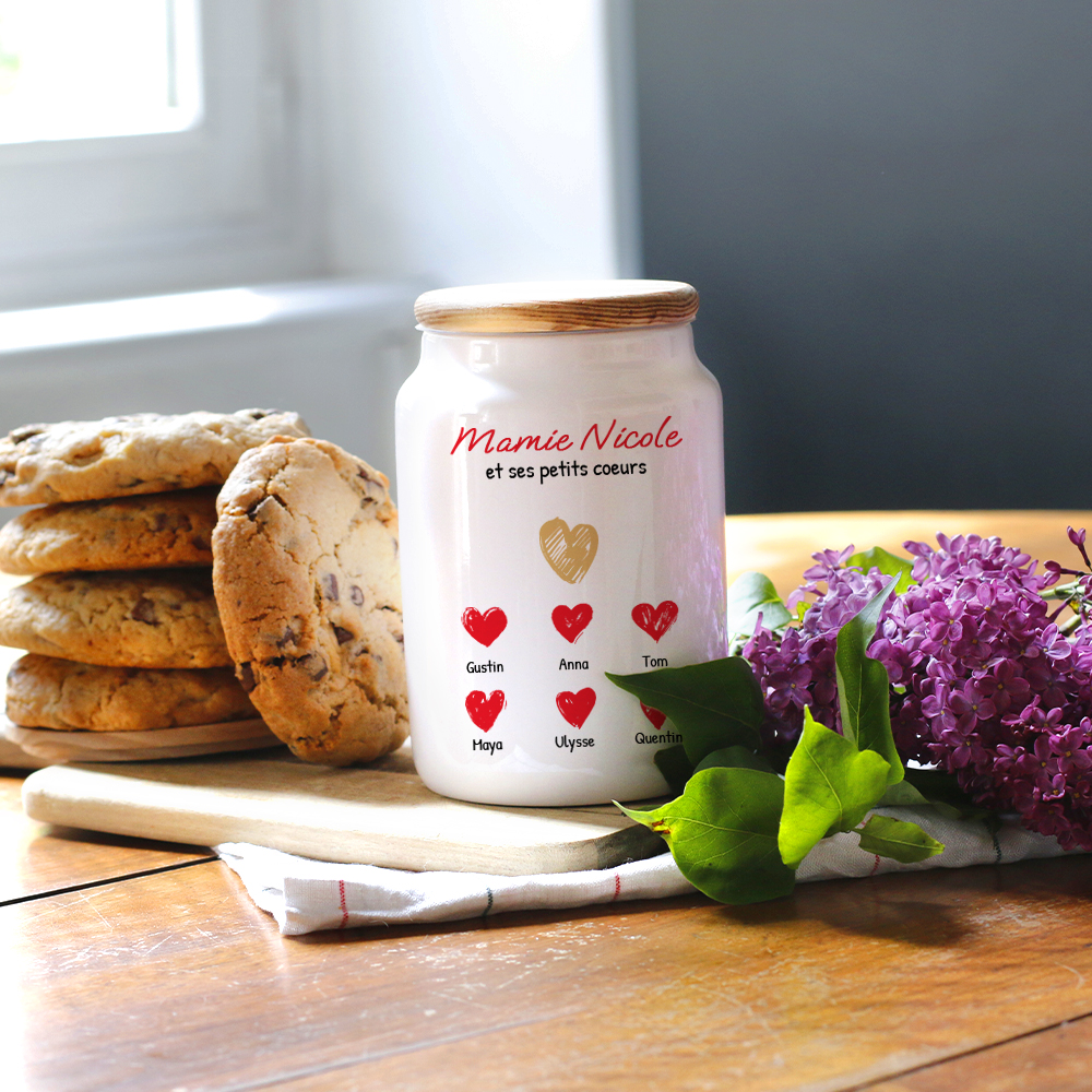 Cadeau Fête des grands-mères : pot à biscuits en céramique blanche 'Mamie et ses petits cœurs' avec prénoms personnalisés, sur table de cuisine.